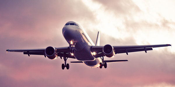 Airplane flying through pink sunset. Jets. U.S. Global Investors.